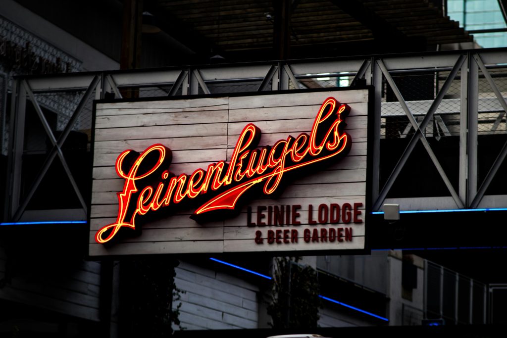 Vibrant neon sign promoting a beer garden, captured at night with warm lighting and modern design.